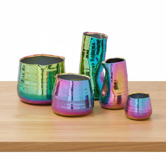 Five iridescent stoneware Tegan pots with oil-slicked glaze in various organic shapes and sizes on a wooden surface.